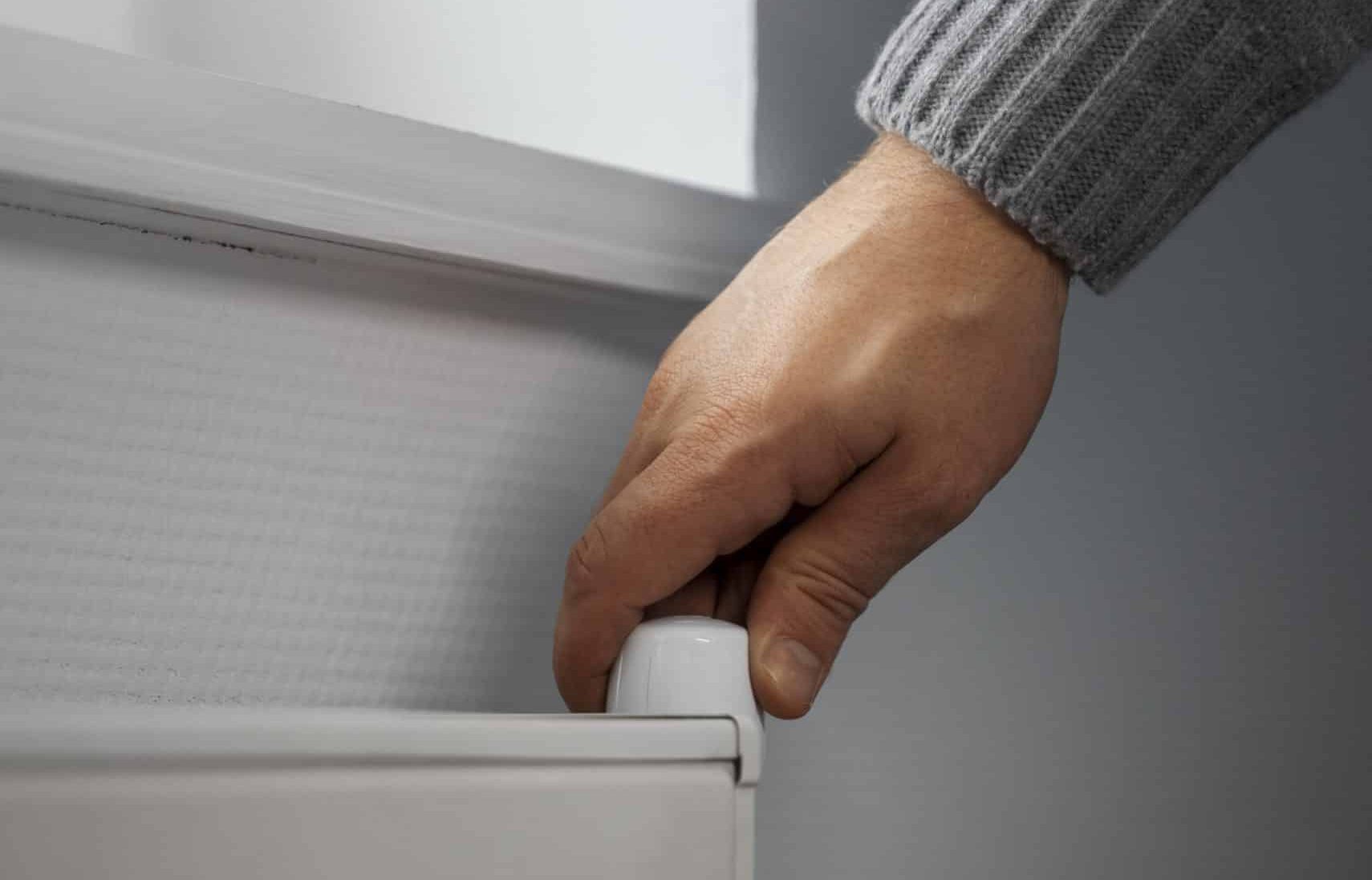 man turning off radiator energy crisis